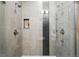 This is a dual shower with gray tiling and mosaic accents and a small shelf for storage at 2830 W 32Nd Ave, Denver, CO 80211