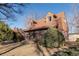 Two-story brick home showing mature landscaping, walkway to front door, and side chimney on a sunny day at 1996 S Linden Ct, Denver, CO 80224