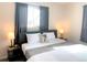Bedroom featuring a bed, side tables, lamps and cozy bedding at 2200 W Moffat Pl, Denver, CO 80221