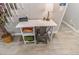 Small writing desk with chair and shelf underneath sits next to the stairs with wood look tile floors at 2200 W Moffat Pl, Denver, CO 80221