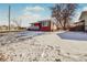 Ranch style home with brick exterior, snowy yard, and a tree in front at 2200 W Moffat Pl, Denver, CO 80221