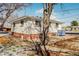 Home featuring brick and stucco, a flat roof, and mature tree in the front yard at 2200 W Moffat Pl, Denver, CO 80221