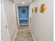 Hallway features wood look tile floors and blue accent wall with shelves and gold decorations at 2200 W Moffat Pl, Denver, CO 80221