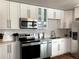 Well-lit kitchen with modern stainless steel appliances, sleek white cabinets and light countertops at 2200 W Moffat Pl, Denver, CO 80221