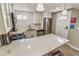 Bright kitchen features stainless steel appliances, white cabinets, subway tile backsplash, and quartz countertop island at 2200 W Moffat Pl, Denver, CO 80221
