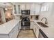 Bright kitchen featuring white cabinets, stainless steel appliances, and efficient layout at 2200 W Moffat Pl, Denver, CO 80221