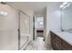 Bathroom featuring a glass-enclosed shower with a bench, a vanity with a sink and a view of the bedroom at 17402 W 93Rd Pl, Arvada, CO 80007