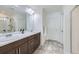 Elegant bathroom with double sinks, white counters, and a glass-enclosed shower at 17402 W 93Rd Pl, Arvada, CO 80007