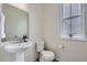 Half bathroom with a pedestal sink, toilet, and window offering natural light at 17402 W 93Rd Pl, Arvada, CO 80007