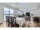 Bright dining area connected to the living room, featuring large windows and stylish furniture at 17402 W 93Rd Pl, Arvada, CO 80007