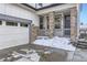 Inviting front porch with stone pillars and a railing, leading to the front door and attached garage at 17402 W 93Rd Pl, Arvada, CO 80007