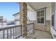Cozy front porch showcasing stone accents and a railing, offering a welcoming entrance to the home at 17402 W 93Rd Pl, Arvada, CO 80007