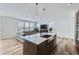 Bright, open-concept kitchen with stainless steel sink, marble counters, and adjacent living area at 17402 W 93Rd Pl, Arvada, CO 80007