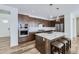 Modern kitchen with stainless steel appliances, a center island with seating, and custom cabinetry at 17402 W 93Rd Pl, Arvada, CO 80007