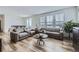 Bright and airy living room with hardwood floors, neutral-toned furniture, and large windows at 17402 W 93Rd Pl, Arvada, CO 80007