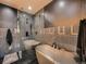 Sleek bathroom with black and gray textured walls, glass enclosed shower and soaking tub at 1401 Delgany St # 409, Denver, CO 80202