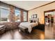 Bedroom with brick wall accent and wood flooring leads to living room and fireplace at 1401 Delgany St # 409, Denver, CO 80202