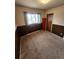 A small bedroom featuring wood paneling, a window, and baseboard heating at 12116 W Texas Dr, Lakewood, CO 80228