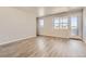 Bright living room featuring neutral paint, wood-look flooring, and a large window at 6993 Ipswich Ct, Castle Pines, CO 80108