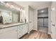 Bathroom featuring dual sinks with granite counters, wood-look floors, and a walk-in closet at 5256 Trails Edge Ln, Castle Rock, CO 80104