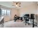 Carpeted bedroom with a large window, ceiling fan, and dedicated desk area with ergonomic chairs at 5256 Trails Edge Ln, Castle Rock, CO 80104