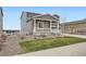 Attractive two-story home with stone accents, a porch, and a green lawn at 5256 Trails Edge Ln, Castle Rock, CO 80104