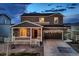 Charming two-story home with a stone facade and inviting front porch at dusk at 5256 Trails Edge Ln, Castle Rock, CO 80104
