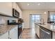 Bright kitchen boasts granite countertops, stainless steel appliances, modern cabinetry, and access to the outdoor deck at 5256 Trails Edge Ln, Castle Rock, CO 80104