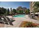 Beautiful outdoor pool surrounded by trees and lounge chairs in a courtyard setting at 1301 Speer Blvd # 309, Denver, CO 80204