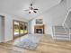 Bright living room featuring vaulted ceiling, fireplace, fan, and patio doors to the outdoor area at 655 Gooseberry Ct, Lafayette, CO 80026