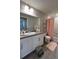 Bathroom featuring a sink, toilet, shower with a curtain, white cabinets, and a large mirror at 12901 Crane River Dr, Longmont, CO 80504
