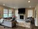Living room featuring a modern fireplace, large windows, neutral color palette and plush seating at 12901 Crane River Dr, Longmont, CO 80504
