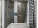 Updated bathroom featuring tiled shower and tub with decorative black and white curtain at 10978 Roseanna Dr, Northglenn, CO 80234