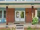 Inviting front porch with double doors, brick accents, and decorative plants at 10978 Roseanna Dr, Northglenn, CO 80234