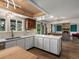 Open kitchen design with modern white cabinets and countertops flowing into living room with fireplace and custom shelving at 10978 Roseanna Dr, Northglenn, CO 80234