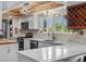 Bright kitchen featuring white cabinets, stainless appliances, and quartz countertops under a custom wood beam ceiling at 10978 Roseanna Dr, Northglenn, CO 80234