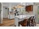 Updated kitchen featuring white cabinets, stainless appliances, quartz countertops, breakfast bar and modern lighting at 10978 Roseanna Dr, Northglenn, CO 80234