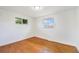 Bedroom featuring refinished hardwood floors and two windows for ample natural light at 2280 Sherrelwood Dr, Denver, CO 80221