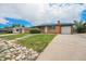 Charming single-story brick home with a well-manicured lawn, driveway, and attached garage at 2280 Sherrelwood Dr, Denver, CO 80221