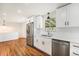 Updated kitchen with stainless steel appliances, white cabinets, and hardwood floors at 2280 Sherrelwood Dr, Denver, CO 80221