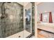 Modern bathroom featuring a glass-enclosed shower with stylish tile and a glimpse into the bedroom at 3383 S Ogden St, Englewood, CO 80113