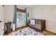Cozy Bedroom featuring a wooden crib, soft blue curtains, and a decorative rug at 3383 S Ogden St, Englewood, CO 80113