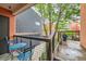 Relax on this balcony with blue furniture, a vibrant potted plant, and a view of the surrounding buildings at 801 Confidence Dr # 16, Longmont, CO 80504