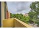 A view from a yellow balcony shows mature trees and colorful urban architecture on an overcast day at 801 Confidence Dr # 16, Longmont, CO 80504