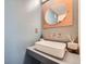 Stylish bathroom featuring a modern vessel sink, copper fixtures, and a round accent mirror at 801 Confidence Dr # 16, Longmont, CO 80504