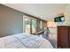 Comfortable bedroom features a balcony, gray walls, modern ceiling lights, and a wall-mounted TV at 801 Confidence Dr # 16, Longmont, CO 80504