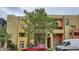 A modern townhouse showcases colorful exterior paint, windows, balconies, and a large tree in the front at 801 Confidence Dr # 16, Longmont, CO 80504