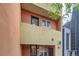 A vibrant townhouse featuring colorful exterior paint, balconies, a front door, and black trimmed windows at 801 Confidence Dr # 16, Longmont, CO 80504