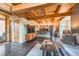 An open-concept living room boasts high beamed ceilings with a kitchen, dark floors, and modern furniture at 801 Confidence Dr # 16, Longmont, CO 80504
