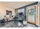 Home office featuring a bike, standing desk, and natural light from a wooden-framed glass door at 801 Confidence Dr # 16, Longmont, CO 80504